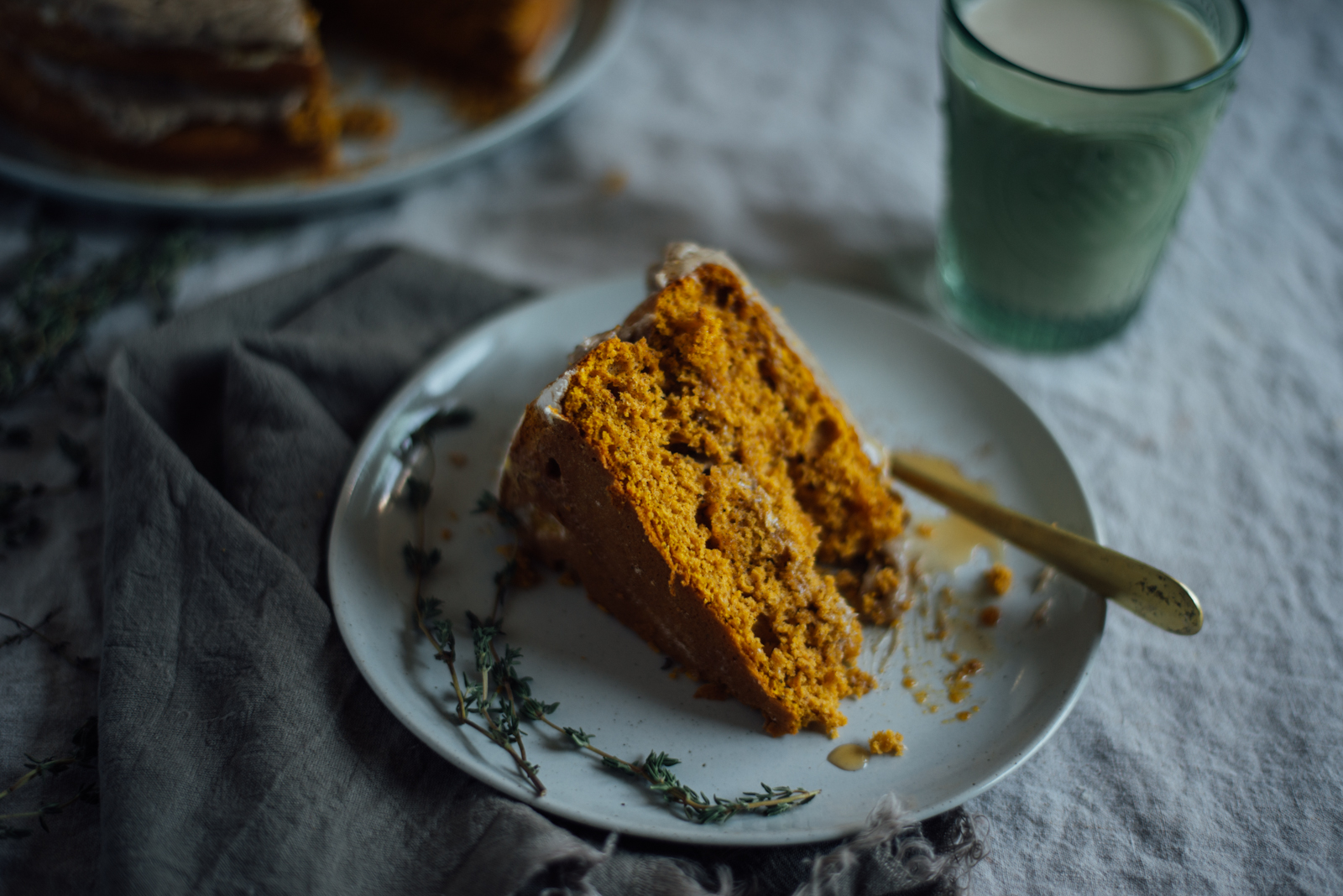 slice of pumpkin cake with browned butter frosting on linen tablecloth