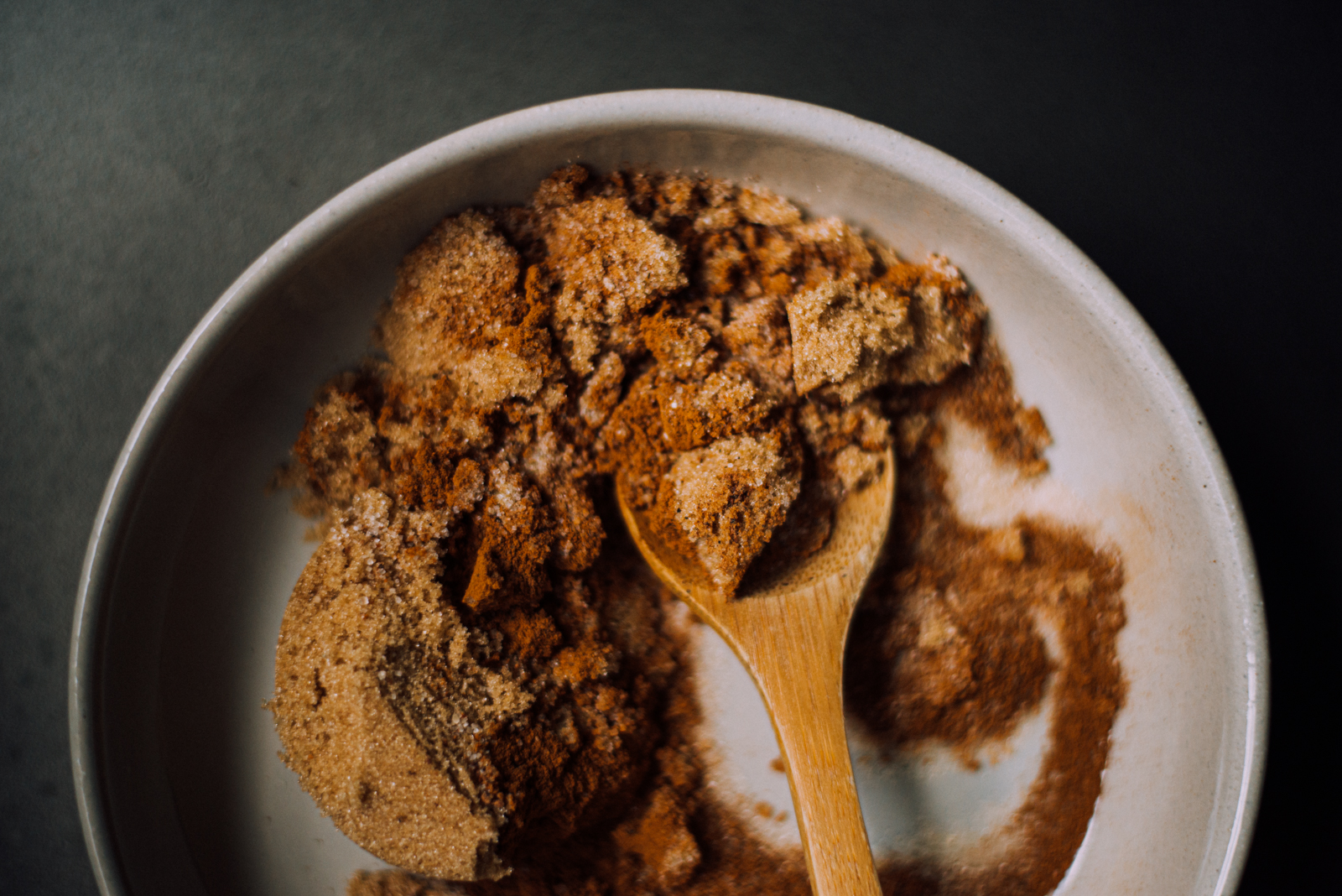 brown sugar, cinnamon, and spices mixed with wooden spoon for pumpkin cinnamon roll filling