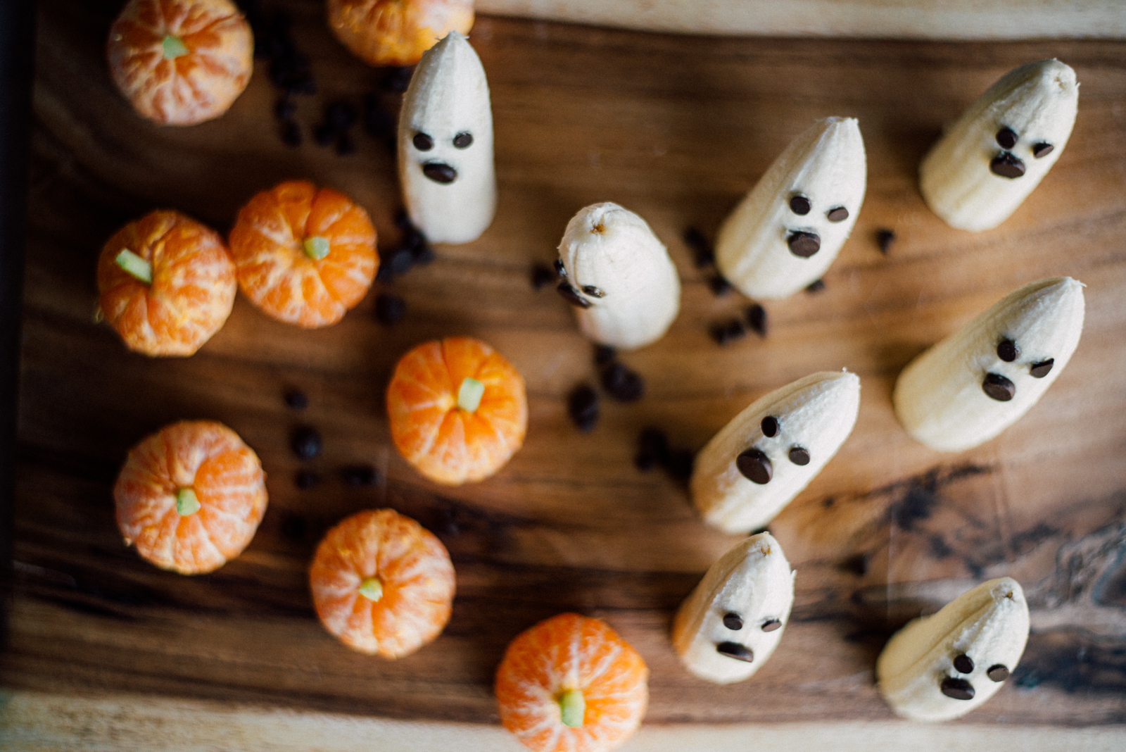 tangerines with celery sticks turned into edible pumpkins with banana ghosts and chocolate chips
