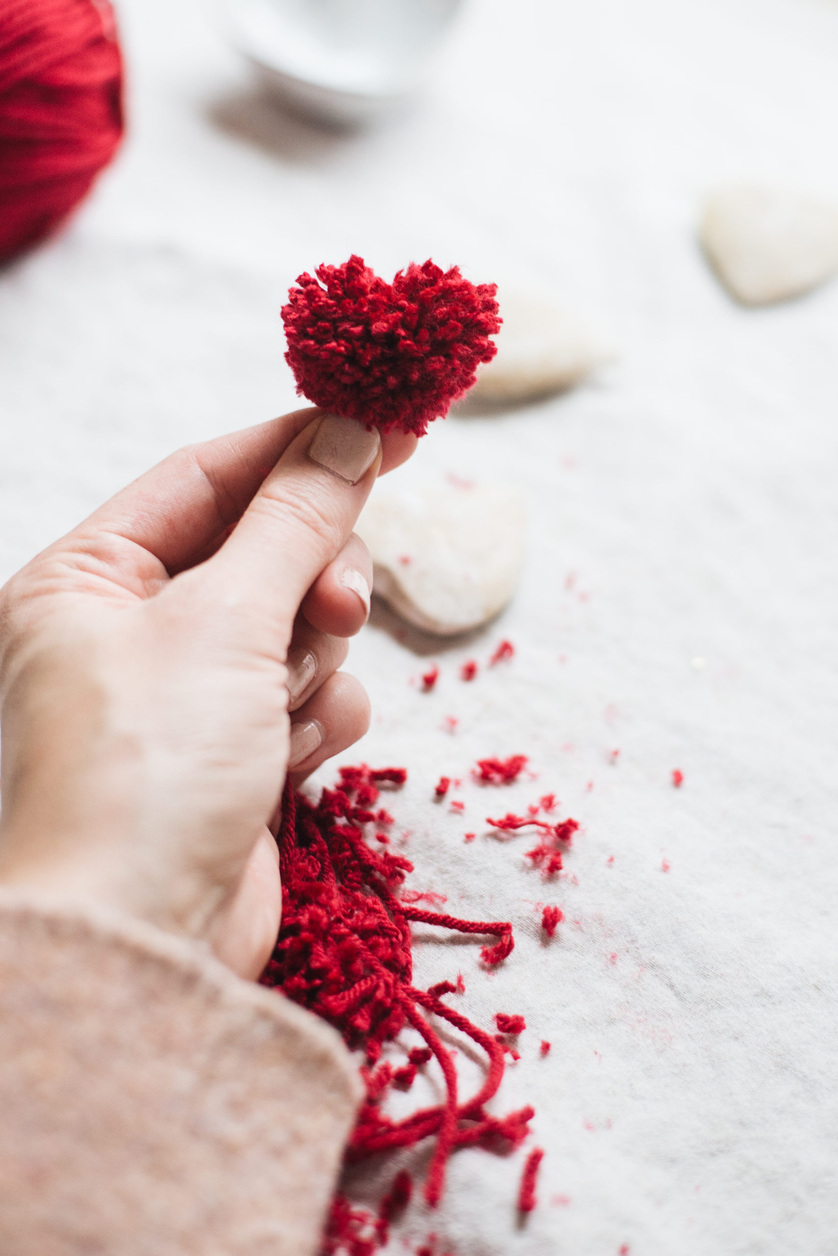 trim red yarn heart pom poms to desired shape casey wiegand