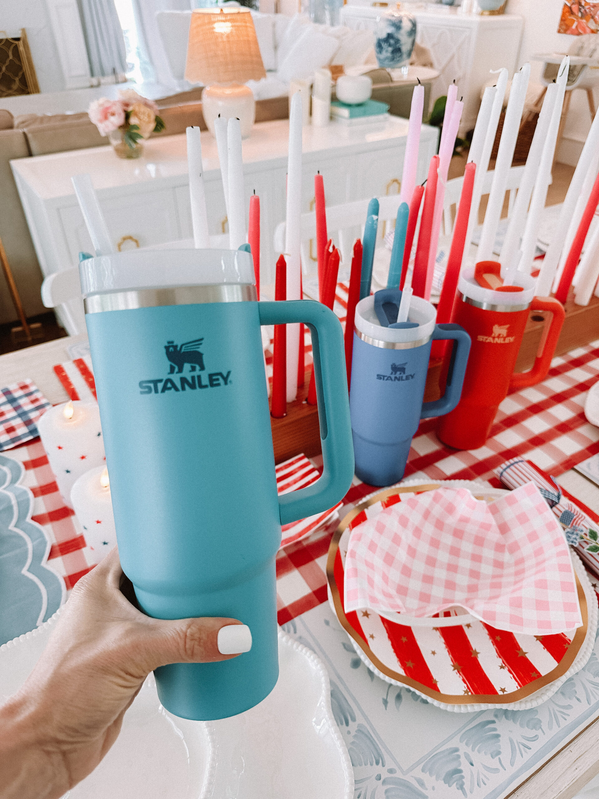stanley everyones viral tumbler favorite drink for moms 4th of July Table Setting Red Gingham Table Runner Flag Plates Scalloped Plates Wood Candle Holder Star Candles Set Stanley Cup in Pool Patriotic Dinner Table Family 4th of July Celebration 4th of July Backyard Party